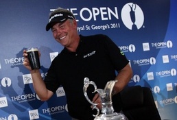 Darren Clarke arrives with a pint of Guinness for a press conference on Sunday after winning the Open Clarke parties all night after British Open triumph