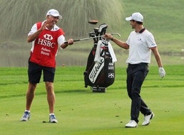 Steve Williams (left) collects a club from Adam Scott during the HSBC Champions golf tournament in Shanghai today Tiger Woods' former caddy in racist outburst